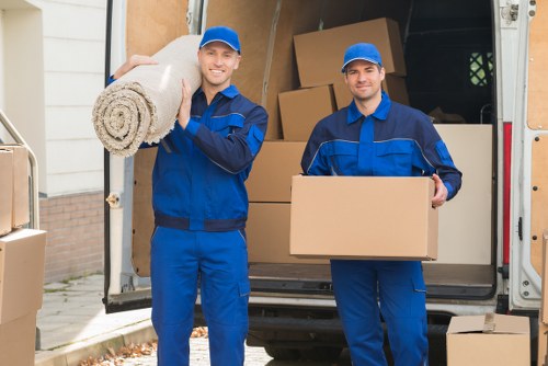 Local movers carrying furniture through a Bloomsbury property